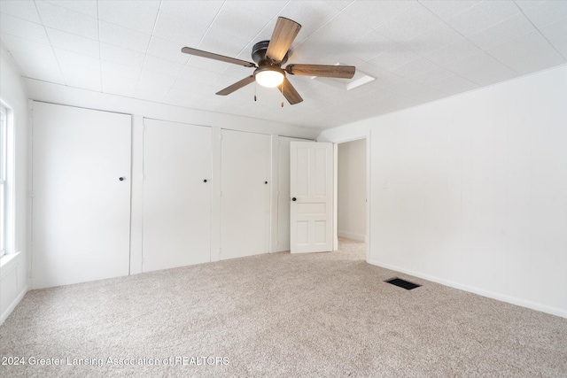 unfurnished bedroom featuring ceiling fan and carpet