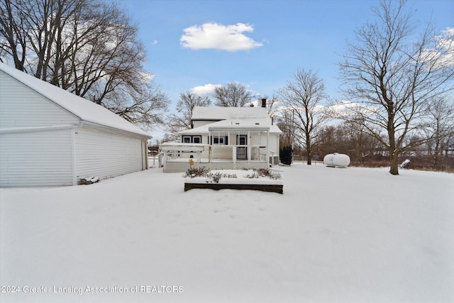 snow covered property with covered porch