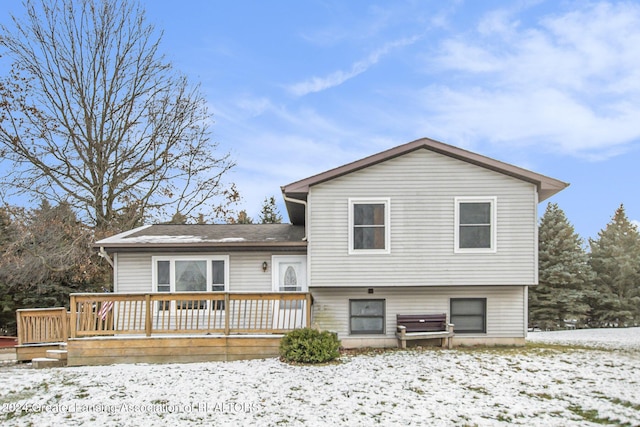 snow covered rear of property featuring a deck