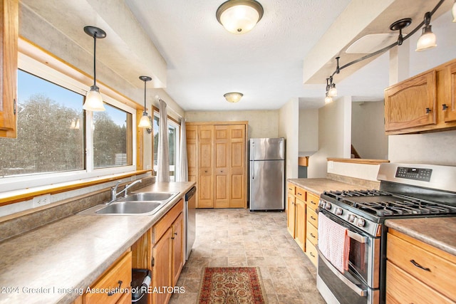 kitchen with sink, pendant lighting, and appliances with stainless steel finishes