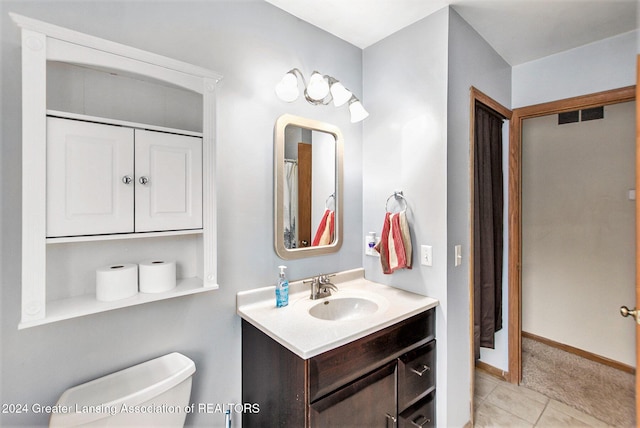 bathroom featuring tile patterned flooring, vanity, and toilet