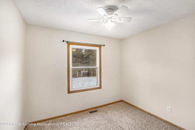 carpeted empty room featuring a textured ceiling and ceiling fan