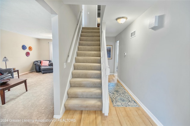 stairs featuring hardwood / wood-style floors