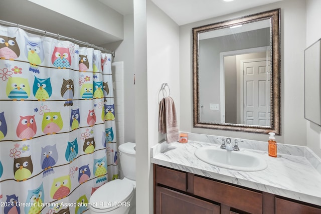 bathroom with vanity, curtained shower, and toilet