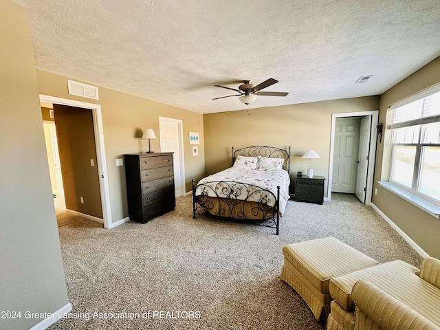 bedroom featuring a textured ceiling, carpet floors, and ceiling fan