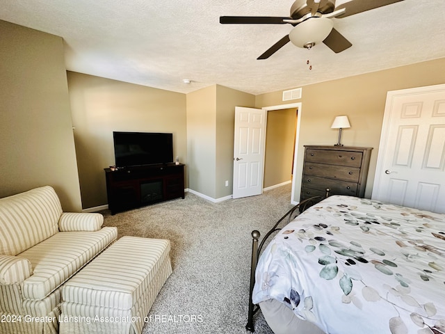 bedroom with a textured ceiling, ceiling fan, and light colored carpet