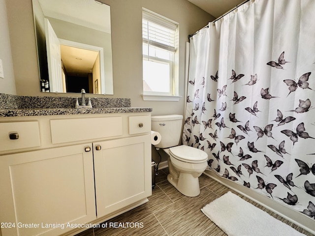 bathroom with a shower with curtain, vanity, and toilet