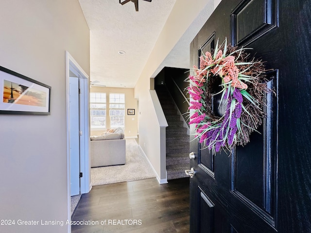 hallway featuring a textured ceiling and dark wood-type flooring