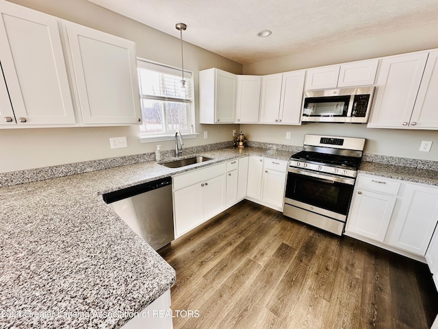 kitchen featuring appliances with stainless steel finishes, white cabinets, and sink