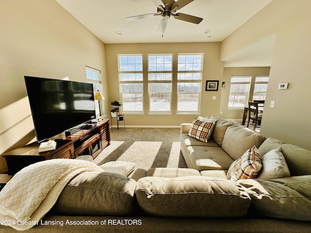 carpeted living room with ceiling fan