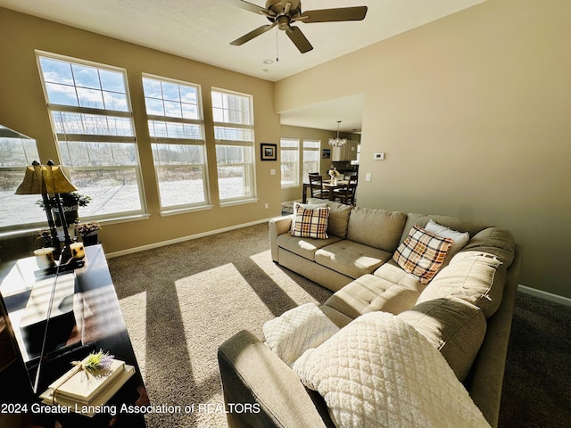 living room with ceiling fan with notable chandelier and carpet