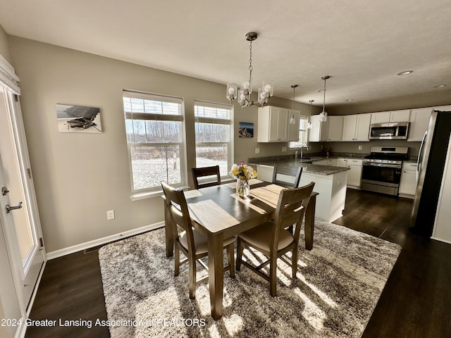 dining room with sink, an inviting chandelier, and dark hardwood / wood-style floors