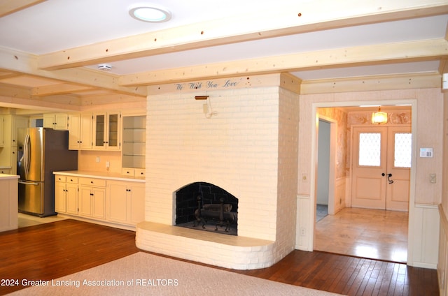 unfurnished living room with french doors, dark hardwood / wood-style flooring, and a brick fireplace