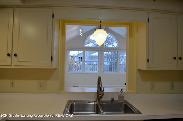 kitchen with vaulted ceiling, hanging light fixtures, and sink