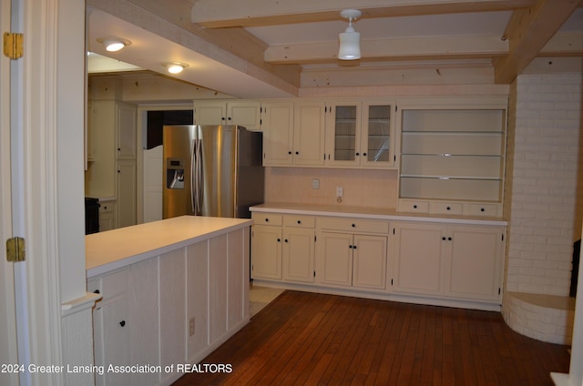 kitchen featuring stainless steel refrigerator with ice dispenser, dark wood-type flooring, white cabinets, and beamed ceiling