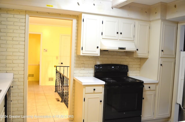 kitchen featuring light tile patterned floors, white cabinetry, decorative backsplash, and black range with electric stovetop