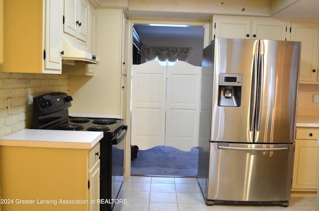 kitchen featuring stainless steel refrigerator with ice dispenser, light tile patterned floors, black / electric stove, and tasteful backsplash