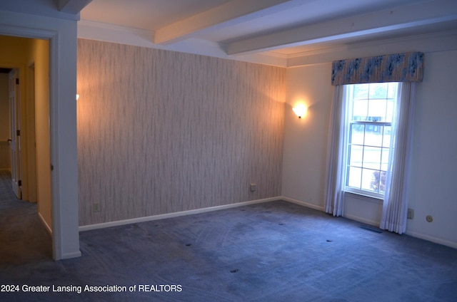 unfurnished room featuring a wealth of natural light, beamed ceiling, and dark colored carpet