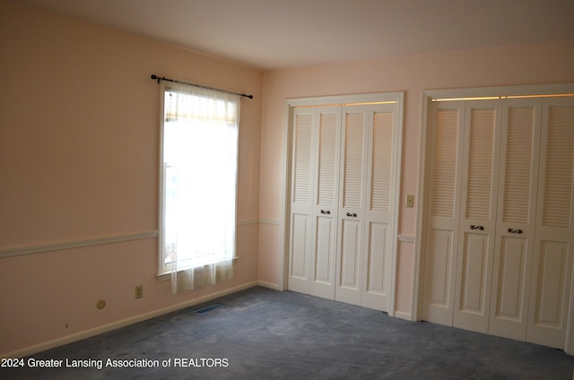 unfurnished bedroom with dark carpet