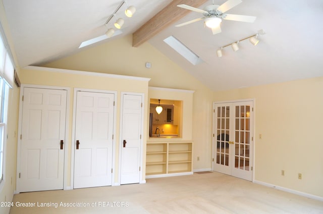 unfurnished bedroom with ceiling fan, lofted ceiling with skylight, sink, carpet flooring, and french doors