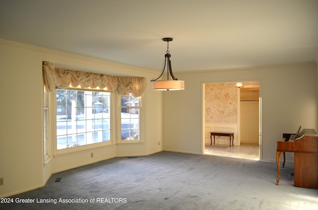 unfurnished dining area with carpet and crown molding