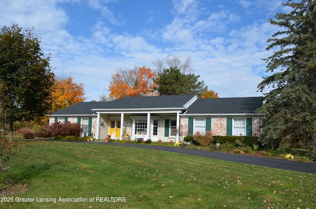 single story home with a front lawn, brick siding, and a porch