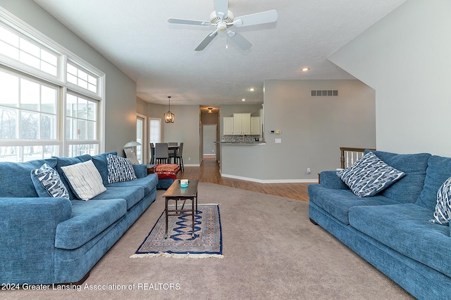 living room featuring light wood-type flooring and ceiling fan