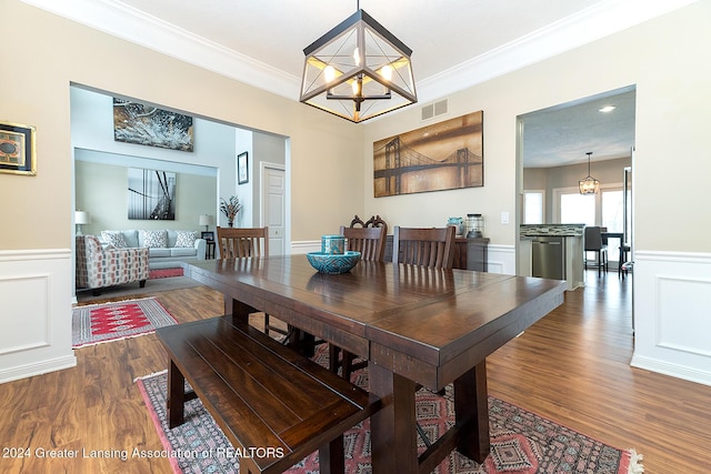 dining space featuring a chandelier, dark hardwood / wood-style floors, and ornamental molding