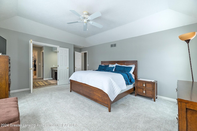 carpeted bedroom with ensuite bathroom, ceiling fan, and lofted ceiling