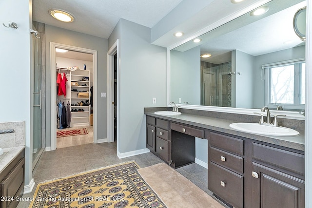 bathroom featuring tile patterned floors, an enclosed shower, vanity, and a textured ceiling