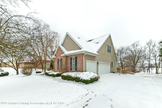 view of snow covered exterior featuring a garage