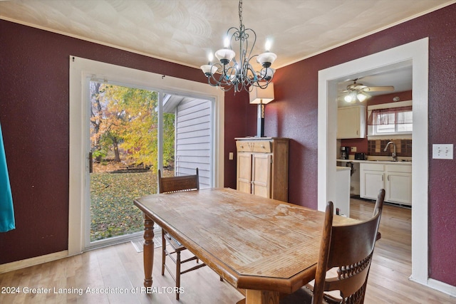 dining room with ceiling fan with notable chandelier, light hardwood / wood-style floors, ornamental molding, and sink