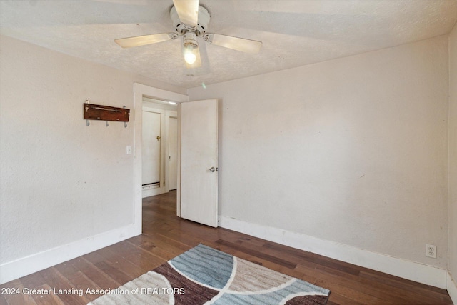 unfurnished room with ceiling fan and dark wood-type flooring