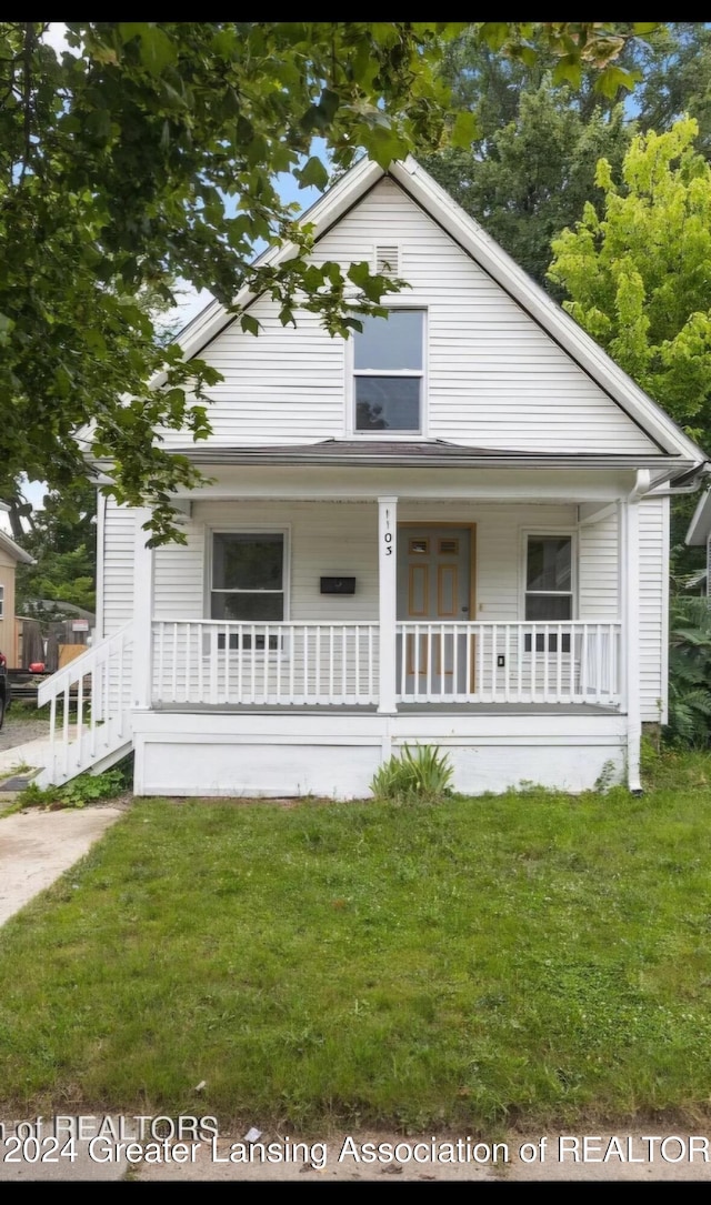 bungalow-style home with covered porch and a front yard