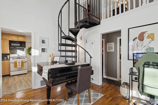 dining space featuring dark hardwood / wood-style floors and a towering ceiling