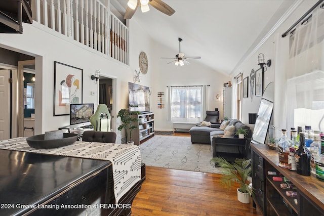 living room featuring hardwood / wood-style flooring, ceiling fan, and high vaulted ceiling