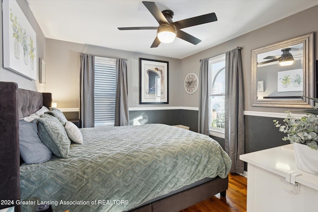 bedroom with multiple windows, ceiling fan, and dark wood-type flooring