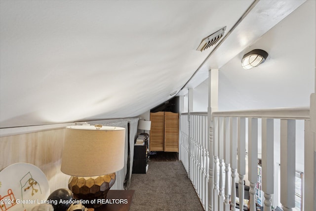 additional living space with dark colored carpet and lofted ceiling