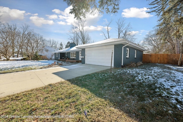 view of snow covered exterior featuring a lawn and a garage