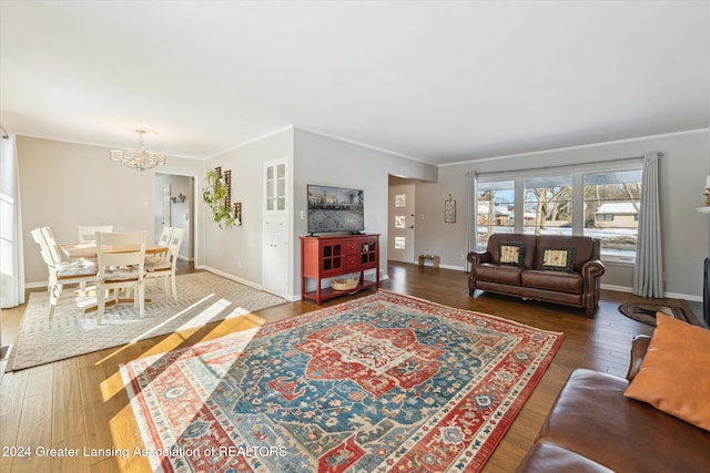 living room featuring ornamental molding, dark hardwood / wood-style floors, and a notable chandelier