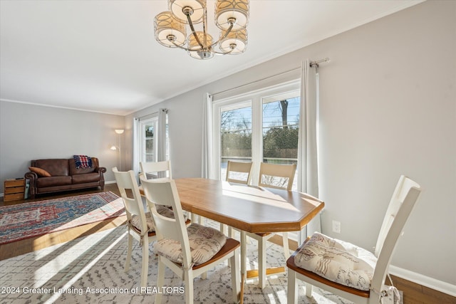 dining room featuring hardwood / wood-style flooring, ornamental molding, and a chandelier