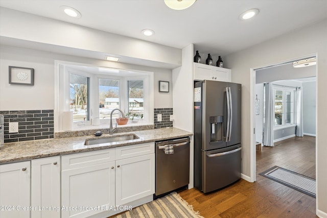 kitchen with white cabinets, light stone counters, sink, and stainless steel appliances