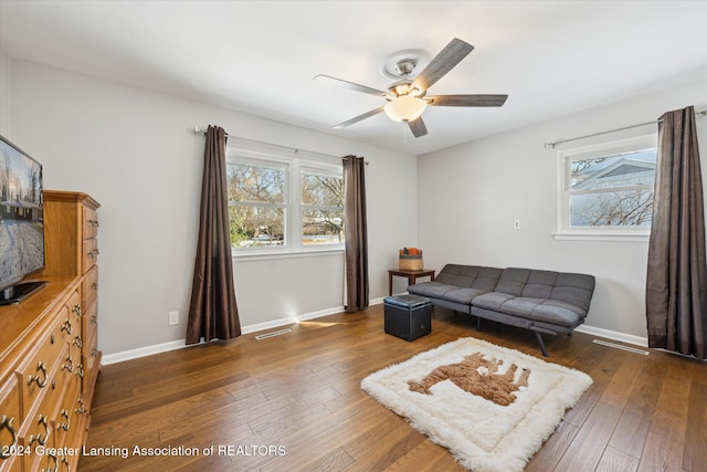 living room with ceiling fan and dark hardwood / wood-style flooring