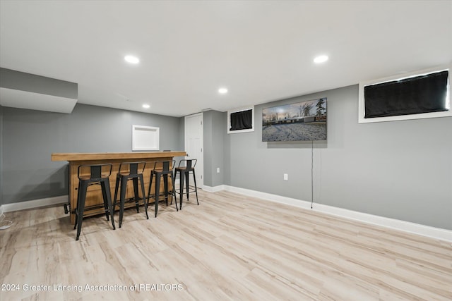 bar with light hardwood / wood-style floors