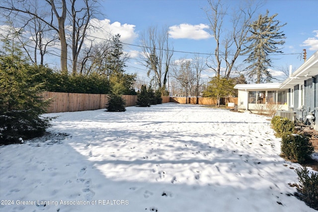 snowy yard with a sunroom