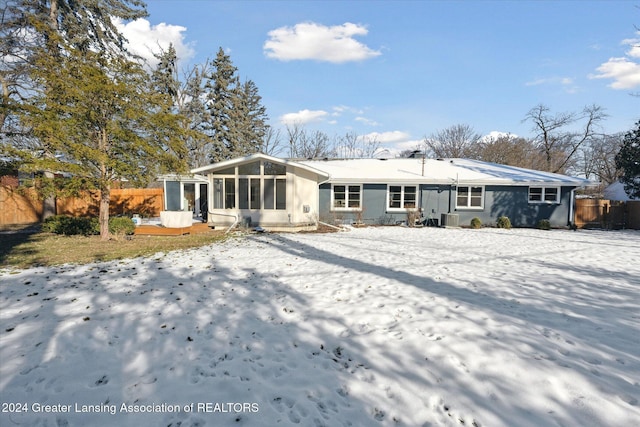 snow covered property with cooling unit and a sunroom