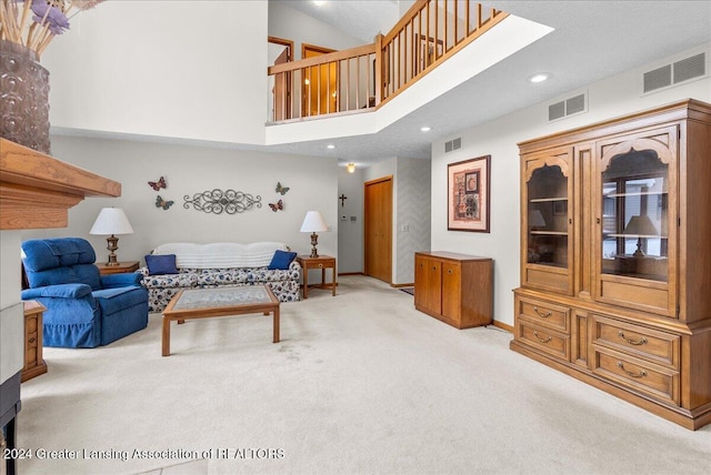 carpeted living room featuring a towering ceiling