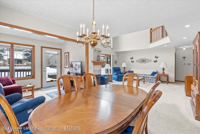 carpeted dining area featuring a textured ceiling, a chandelier, and a fireplace