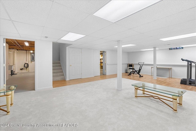 basement featuring a paneled ceiling and hardwood / wood-style floors