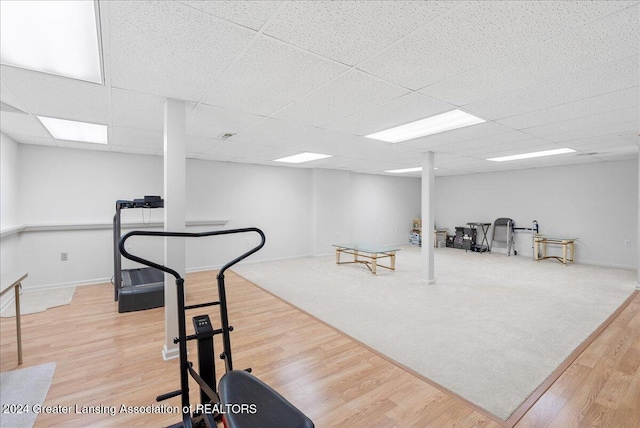 workout area featuring hardwood / wood-style flooring and a paneled ceiling